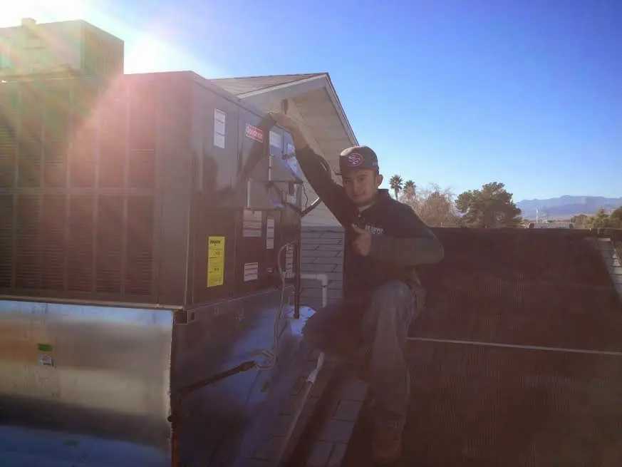 HVAC technician performing HVAC Inspection on a rooftop unit in Medina