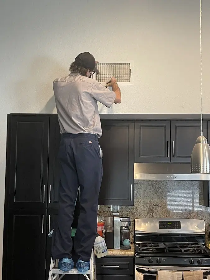 Technician inspecting an air vent during HVAC service in Medina